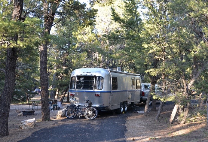 Mather Campground - No hook-ups - 30-foot trailer or RV maximum Open year-round. Operated by the National Park Service and located in Grand Canyon Village, this campground offers tent and RV camping. Accessible campsites and restrooms are available. Pets are allowed, but must be leashed at all times, and may not be left unattended. Wood and charcoal fires permitted in provided campsite grills only. No gathering of down wood, wood may be purchased at the general store. Laundry and showers located near the campground for a fee. Reservations may be made through the National Recreation Reservation Service by calling 1-877-444-6777 or online at the http://www.recreation.gov/ Reservations are strongly recommended from March 1 through mid-November. Golden Age or Access passport holders pay only Ω price year round (passport number is needed when making reservation and passport holder must be camping at the site). Fees are $18 per site per night. A maximum of two vehicles, six people, three tents are allowed per site. (A vehicle that is towing a trailer, pop-up, tent trailer, fifth wheel, or a motor home pulling a vehicle is considered two vehicles.) Group sites are also available, $50/night, maximum of 50 people and 3 vehicles per group site. Pets are NOT allowed below the canyon rim at any time. Pets are NOT permitted on the shuttle buses. Kennels are available in the South Rim Village. During the winter, from mid-November through February 28 reservations are not available at Mather Campground and family campsites are $15 per site per night, and group campsites are $30. This is on a first-come first-served basis. There is a self-pay machine at the campground office.